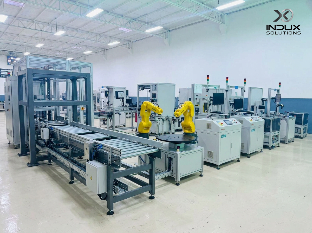 Dual FANUC robots with roller conveyor, rotary indexer, and automated inspection stations